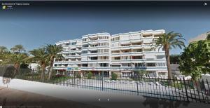 un gran edificio blanco con palmeras en Apartamentos Teror - Yumbo, en Playa del Inglés