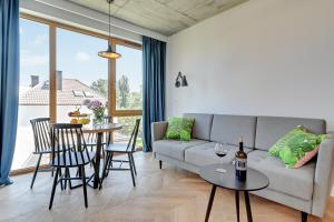 sala de estar con sofá y mesa con sillas en Pogodna Apartments, en Sopot
