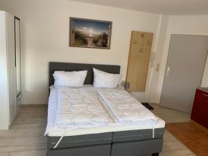 a large bed with white sheets and pillows in a room at Moderne Apartments im Ferienpark auf Rügen in Sagard