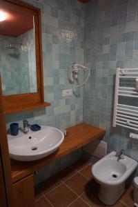 uma casa de banho com um lavatório, um WC e um espelho. em PALAZZO FULGHER em Cagliari