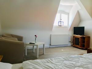 a living room with a bed and a table with a tv at Hafenapartments Zingst in Zingst