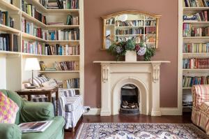 a living room with a fireplace and shelves of books at The Old Monastery Guesthouse in Cahersiveen +36 photos