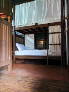 a bedroom with a bunk bed with white sheets at ADRI CHEMBRA in Meppādi