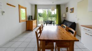 cocina y comedor con mesa de madera y sillas en Vacancéole - Domaine du Green, en Rivières