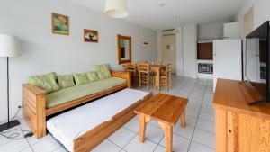 a living room with a couch and a table at Vacancéole - Domaine du Green in Rivières
