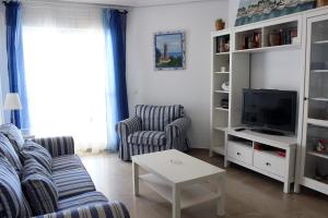 een woonkamer met een bank en een tv bij El FARO 2 in Estepona