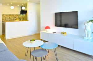 een woonkamer met 2 tafels en een tv bij Stay In Plaza in Alicante
