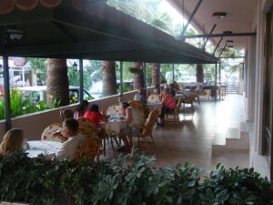 a group of people sitting at tables in a restaurant at Nazar Hotel in Didim