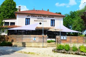 un edificio con una sombrilla delante de él en Logis Le Relais de la Voie Sacrée en Issoncourt