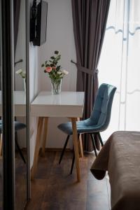 una stanza con tavolo e due sedie e un vaso con fiori di SOBE "GALEB" a Vrbnik