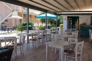 an empty patio with tables and chairs and umbrellas at Primavera Hotel in Dassia