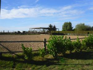 a field with a fence and a building in the background at la mini ferme de maëlou in Sermaises