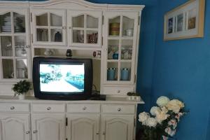 a tv sitting in a white cabinet in a room at Apartamento tranquilo en Granada para 6 personas in Granada