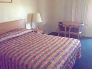 Habitación de hotel con cama y mesa en Hacienda Motel, en San Jacinto