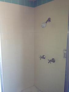 y baño con ducha y 2 grifos. en Hacienda Motel, en San Jacinto