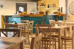 a restaurant with wooden tables and chairs and a counter at Primavera Hotel in Dassia