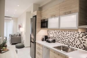 una cucina con lavello e frigorifero di Ammos Elegant Luxury Apartment a Città di Corfù