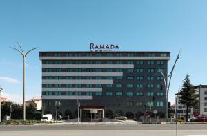 un edificio alto con un cartel encima en Ramada Usak, en Uşak