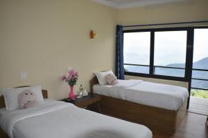 a bedroom with two beds with a stuffed animal on them at Hotel Greenland in Nagarkot