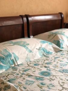 - un lit avec couverture et fleurs bleues dans l'établissement Il Baco Da Seta, à Manta