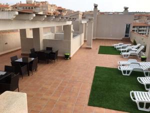 a patio with tables and chairs on a roof at Expoholidays - Apartamentos Puerto Almerimar in Almerimar