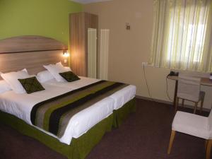 een hotelkamer met een groot bed en een bureau bij Les Étoiles Du Forez in Montbrison +20 foto's