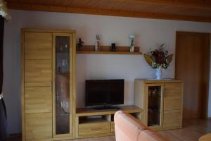 ein Wohnzimmer mit einem TV und einem Schrank in der Unterkunft Ferienwohnung Kagerbauer Christiane in Lindberg