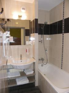 a bathroom with a sink and a bath tub at Les Étoiles Du Forez in Montbrison