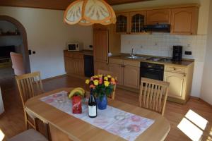 a kitchen with a table with flowers on it at Ferienwohnung Kagerbauer Christiane in Lindberg +12 photos