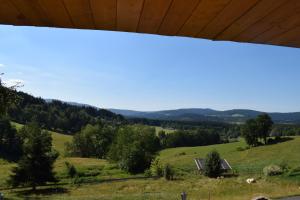 - une vue sur un champ avec une maison au loin dans l'établissement Ferienwohnung Kagerbauer Christiane, à Lindberg