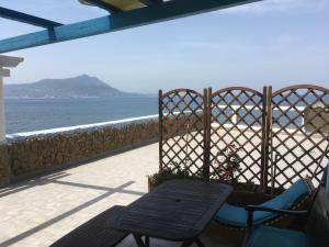 een tafel en stoelen op een balkon met uitzicht op de oceaan bij Azzurromare Residence in Procida
