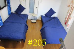 2 łóżka w pokoju z niebieskimi poduszkami w obiekcie マンションロアジス 大阪市東淀川区相川 w Osace
