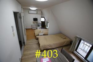 een kleine kamer met een bed en een tafel bij マンションロアジス 大阪市東淀川区相川 in Osaka