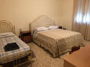 sypialnia z łóżkiem, komodą i stołem w obiekcie Gene Holiday Home w Rawennie