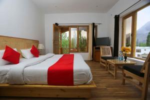 a bedroom with a large bed with red and white sheets at Hunder Residency in Leh