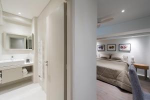 a white bedroom with a bed and a sink at Tourlos Bay Villas Mykonos in Tourlos +38 photos