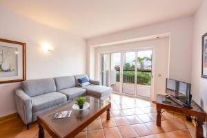 ein Wohnzimmer mit einem Sofa und einem Tisch in der Unterkunft Clube Alvor Ria - Prime Residence in Alvor