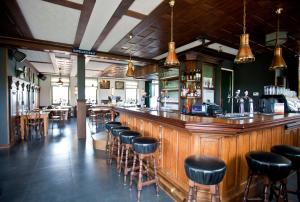 a bar with leather stools in a restaurant at TopParken – Park Westerkogge in Berkhout