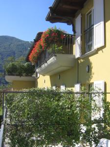 ein Gebäude mit zwei Balkonen mit Blumen darauf in der Unterkunft Hotel Del Fiume in Cannobio