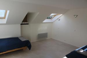 a attic bedroom with a bed and a window at Riders Apartments in Le Bourg-dʼOisans