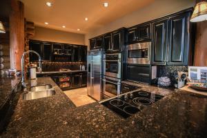 una cocina con armarios negros y electrodomésticos de acero inoxidable en Miracle Lodge, en Leavenworth