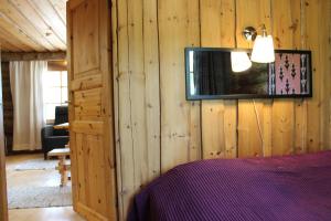 a bedroom with a tv on a wooden wall at Kero 15 in Syöte