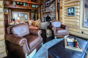 sala de estar con sillas de cuero y mesa en Miracle Lodge, en Leavenworth