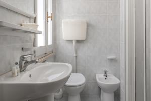 a white bathroom with a sink and a toilet at Hotel Sole Mio in Rimini