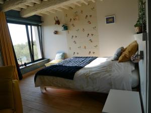 La Maison Forte في Millery: غرفة نوم بسرير وجدار به حيوانات