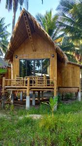 een houten huis met een groot raam ervoor bij Seacroft Bamboo Village in Hinkong