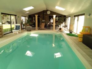 Chez Michel et Josette في Le May-sur-Èvre: مسبح كبير به ماء ازرق في المنزل
