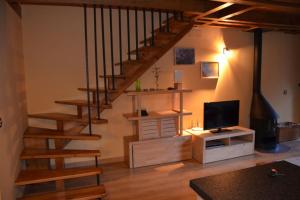 sala de estar con escalera y TV en Laurit, en Bossòst