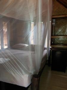 a bedroom with a bed with white mosquito netting at Seacroft Bamboo Village in Hinkong