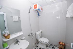 a white bathroom with a toilet and a sink at Nhà Nghỉ Kiên Cường - Kien Cuong Hostel in Cat Ba